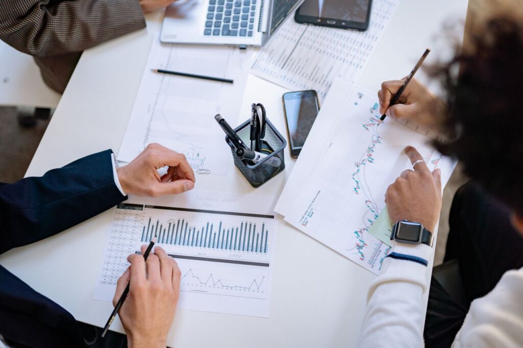 Business team analyzing financial charts and graphs during a collaborative meeting.